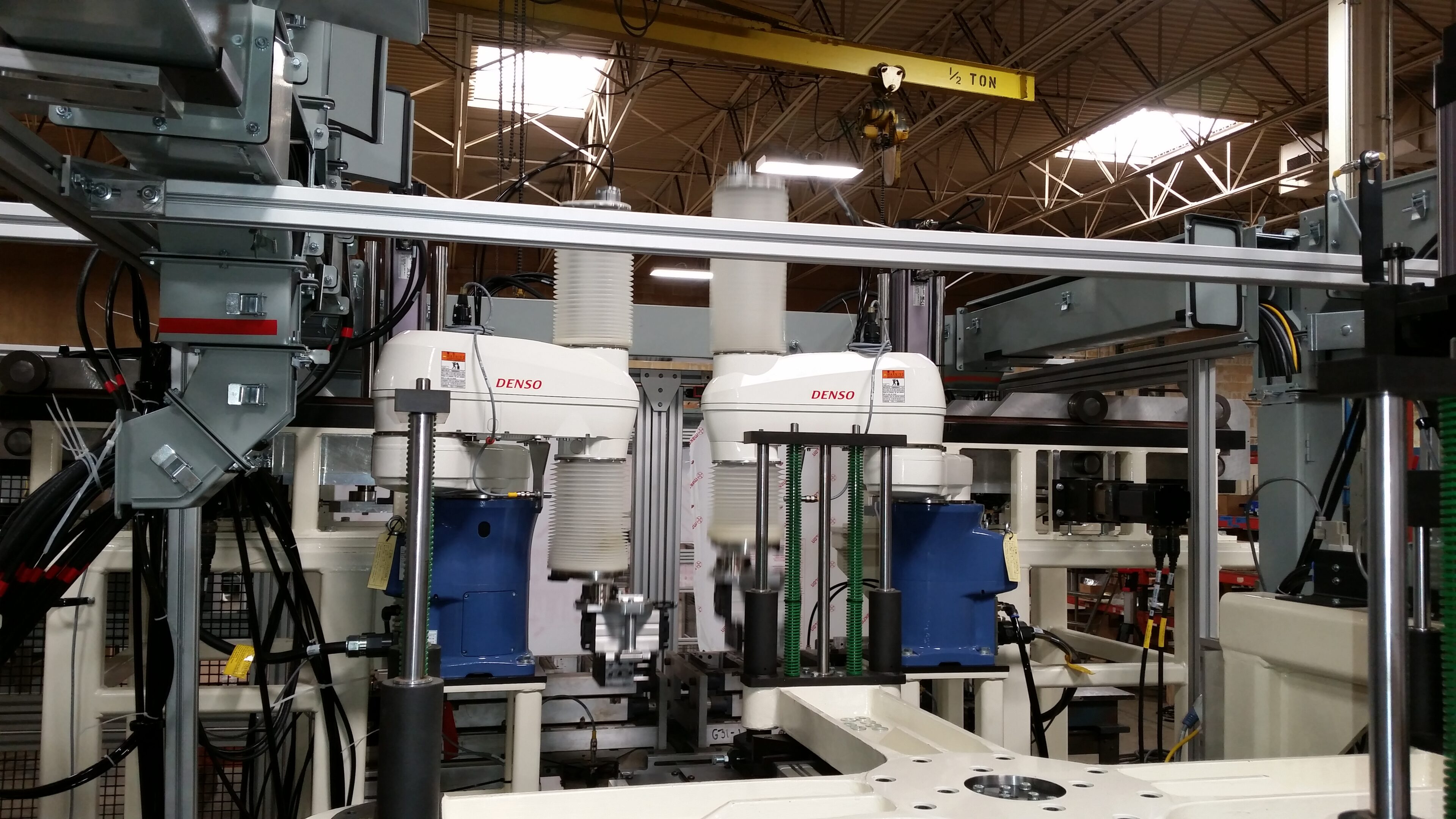Industrial machines with robotic arms in a factory setting.