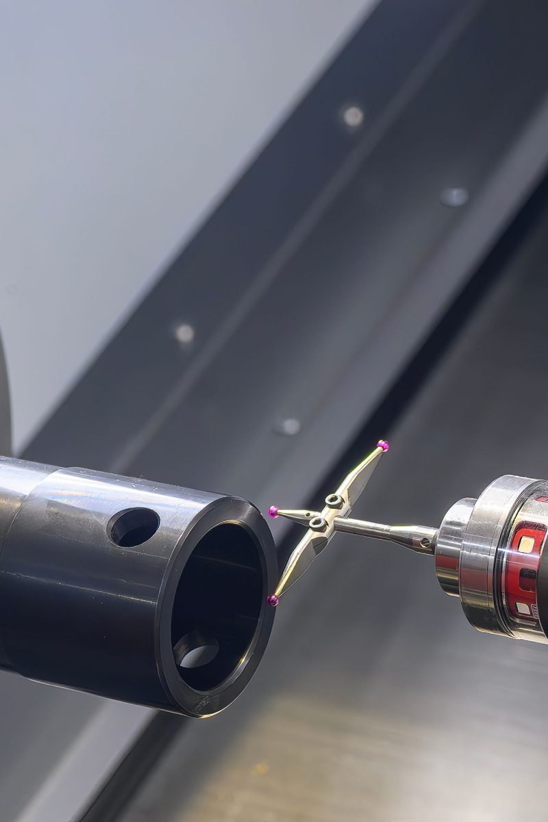 Machine inspecting metal pipe with probe tool.